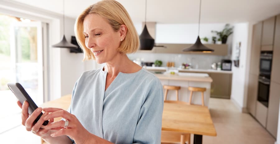 Woman using a smartphone in a room filled with sunlight